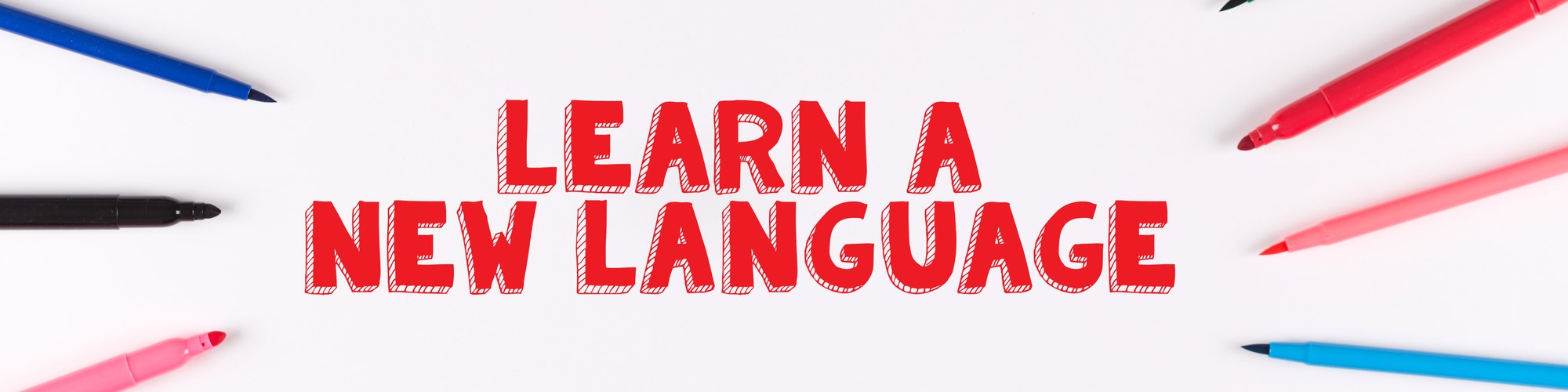Bunte Stifte zeigen auf den Text Learn a new language.